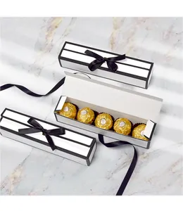 Detail van lange rechthoekige geschenkdozen met zwarte strikken op marmeren blad