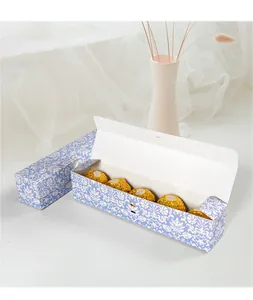 Detail van rechthoekige blauwe bloemen chocoladedoos met vijf goudfolie bonbons