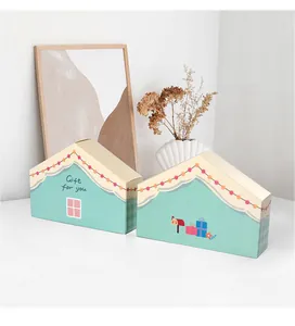 Dettaglio della scatola regalo a forma di casa verde menta con scritta e motivi decorativi