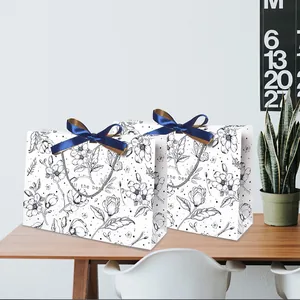 Geschenktüten mit Blumenmuster, blauen Satin-Schleifen und eleganter Strichzeichnung