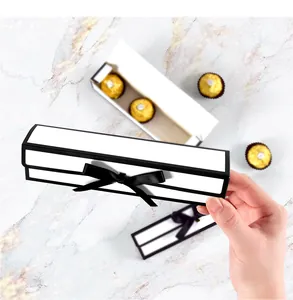 Detail van een witte rechthoekige geschenkdoos met zwart satijnen lint voor 3 bonbons