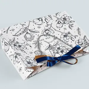 Geschenktüte mit Blumen-Line-Art, silbernen Kordelgriffen und dunkelblauer Schleife
