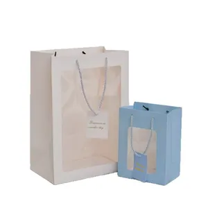 Minimalist paper gift bags in white and blue with clear PVC windows and card tags