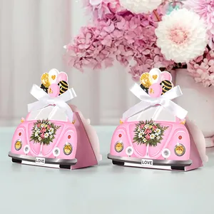 Roze snoepdoosjes in autovorm met bloempatronen en zijden strikken voor bruiloften