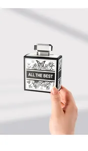 Hand holding perfume bottle shape gift box with floral art and All The Best text