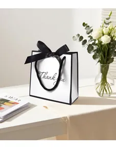 Detailed close-up of white gift bag with black trim and elegant Thank You script