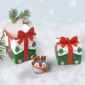 Cartoon Christmas candy gift boxes with red bows and cute felt penguin ornament