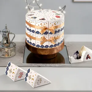 Dreieckige Torten-Geschenkboxen in Weiß mit Goldband und festlichen Sternen-Motiven