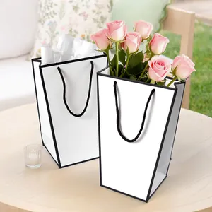 Minimalist white trapezoid gift bag with black trim and handles for flowers and shopping