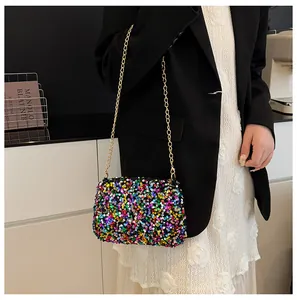 Close-up of colorful sequins and golden chain strap on a stylish bucket bag