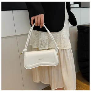 Detail of white leather shoulder bag with XM & BAGS logo and knot handle accents