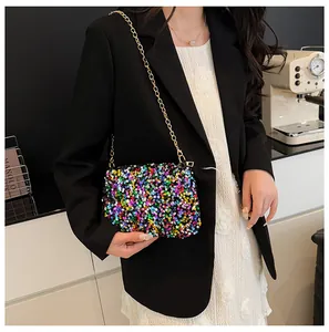 Close-up of vibrant iridescent sequins and gold chain strap on a mini bucket bag
