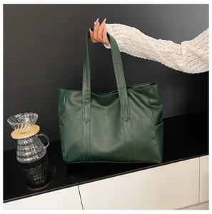 Detail view of large dark green tote bag in textured bark-pattern faux leather