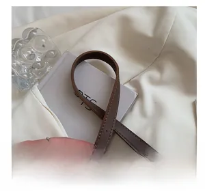 Detail of adjustable brown leather shoulder strap with precision stitching and soft texture