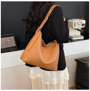 Detail of caramel tote bag with wide adjustable strap and silver metal stud accents