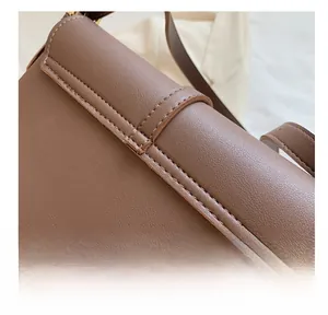Detail of dark brown leather bag showing premium pebbled texture and neat double stitching