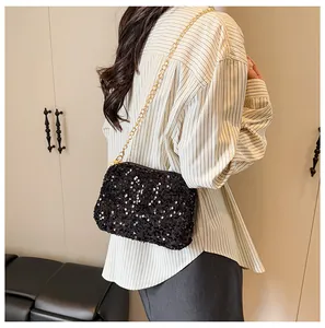Close-up of black sequins texture and golden chain on stylish shoulder bucket bag