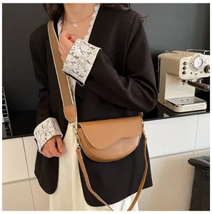 Detail of khaki leather saddle bag showing flap closure and stylish textured surface