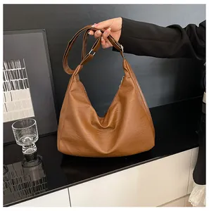 Detail of a brown PU leather hobo tote showing rich texture and adjustable shoulder strap