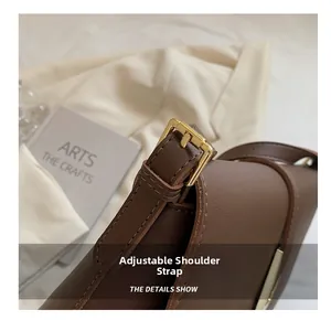 Close-up of the adjustable brown leather strap with a gold metal buckle on the shoulder bag