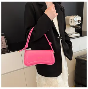 Detail of bright pink shoulder bag with knotted strap and gold hardware accents