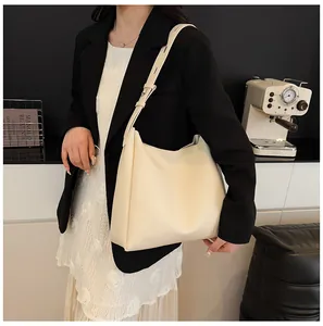 Detailed close-up of cream-colored large tote bag showing soft leather texture and strap