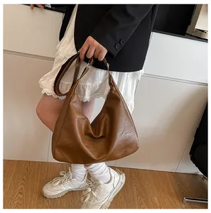 Macro detail of brown textured leather Hobo bag with adjustable strap in casual scene