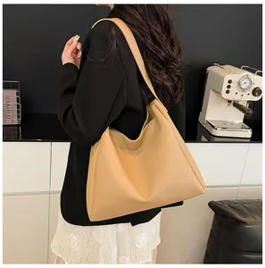 Detailed side view of beige large tote bag showing hobo style and wide shoulder strap