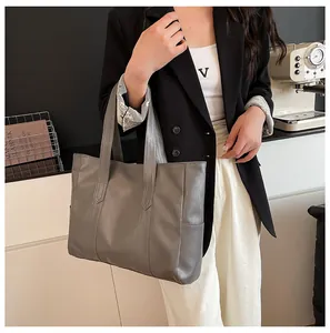 Detailed view of dark grey tote bag with bark texture and wide shoulder strap
