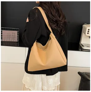 Detailed back view of a khaki large-capacity hobo tote bag on a model in a modern office