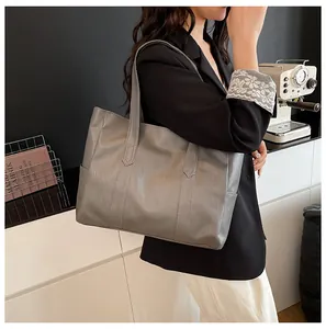 Detailed view of grey tote bag showing matte bark texture and side pocket design