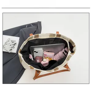 Spacious interior of striped canvas tote bag showing laptop and daily essentials