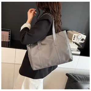 Detail of grey tote bag with bark texture and side pocket shown in city lifestyle setting
