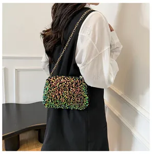 Detail of colorful sequin crossbody bag with gold chain strap on model's shoulder