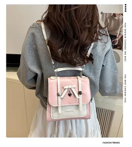 Détail du mini sac à dos rose et blanc avec nœud papillon et pendentif en forme de cœur