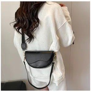 Detailed view of the black PU leather saddle bag showing adjustable strap and gold hardware