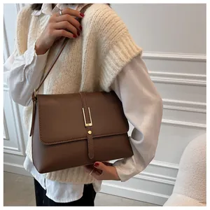 Detail of vintage brown leather bag with golden metallic hardware and textured finish