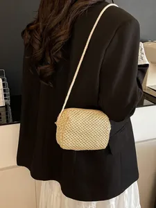 Handwoven beige straw crossbody bag for summer fashion, shown on model back view