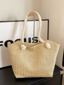 Large woven straw tote bag with white cotton rope handles and minimalist FOCUS background