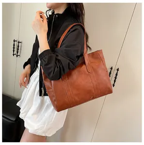 Brown large capacity tote bag with vintage bark texture worn on shoulder by model