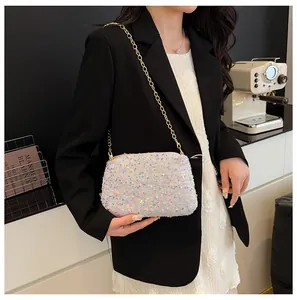 Close-up of sparkling sequin bucket bag with elegant gold chain strap on model