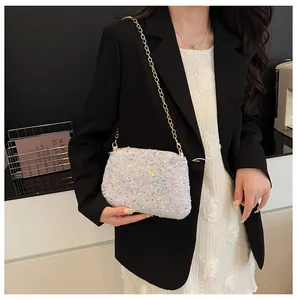 Detail showing the iridescent sequin texture and golden chain strap on the bucket bag