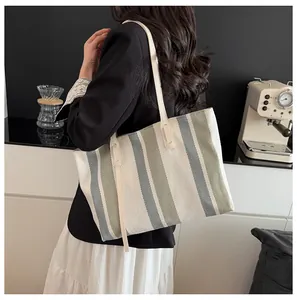 Detailansicht der grau-beige gestreiften gewebten Tragetasche mit schickem Büro-Outfit