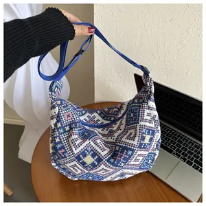 Detailed view of the woven ethnic pattern hobo bag with an adjustable blue strap