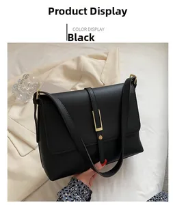 Detail of black crossbody bag with rectangular golden buckle and matte leather texture