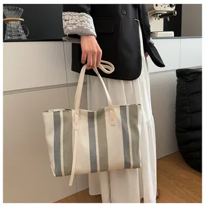 Detailed view of the striped canvas tote bag with olive green and grey color blocking