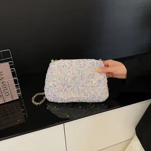 Elegant white sequin bucket bag with gold chain strap for luxury evening wear styling