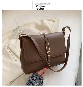 Detail of coffee brown faux leather bag featuring a sleek vertical gold metal clasp