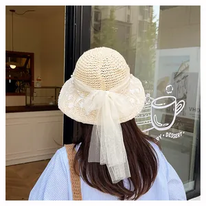 Detail van crème strooien hoed met witte mesh strik en elegante parelversieringen