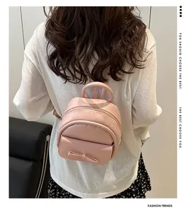 Model wearing a pink mini backpack featuring a decorative bow and high-quality PU leather